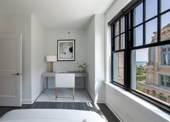 a bedroom with a bed and a desk and large windows  at The Belden Stratford, Chicago, 60614