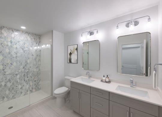 a white bathroom with two sinks and a shower  at The Belden Stratford, Chicago, IL