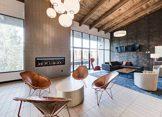 a living room with chairs and couches and a fireplace at Ashford Belmar Apartments, Colorado, 80226
