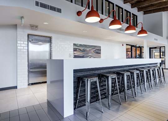 a row of bar stools in front of a long bar with white tiles at Ashford Belmar Apartments, Lakewood, 80226