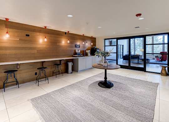 a living room with a bar and a kitchen with glass doors at Ashford Belmar Apartments, Lakewood
