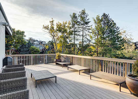 the deck has a view of the mountains and trees at Ashford Belmar Apartments, Lakewood