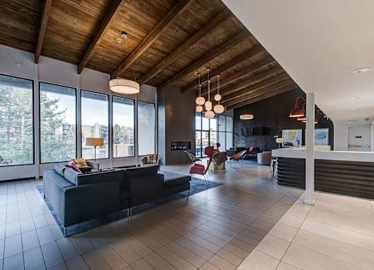 the living room and kitchen of a modern house with large windows at Ashford Belmar Apartments, Lakewood, 80226