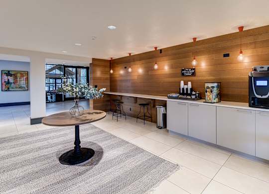 a kitchen with a coffee table and a refrigerator at Ashford Belmar Apartments, Colorado