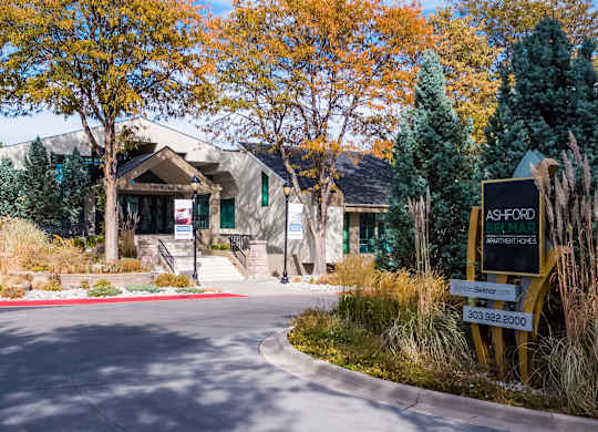 the front of a building with a street sign in front of it at Ashford Belmar Apartments, Lakewood, CO 80226