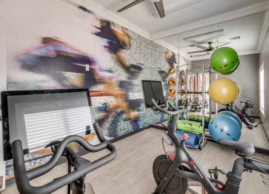 a home gym with exercise bikes and a computer at Carrington at Barker Cypress, Cypress, 77433