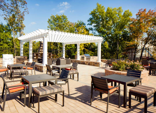 an outdoor patio with tables, chairs and a pergola at Heights at Glen Mills, Glen Mills, Pennsylvania