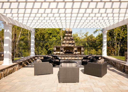 a pergola over a patio with furniture and a fireplace at Heights at Glen Mills, Glen Mills, PA