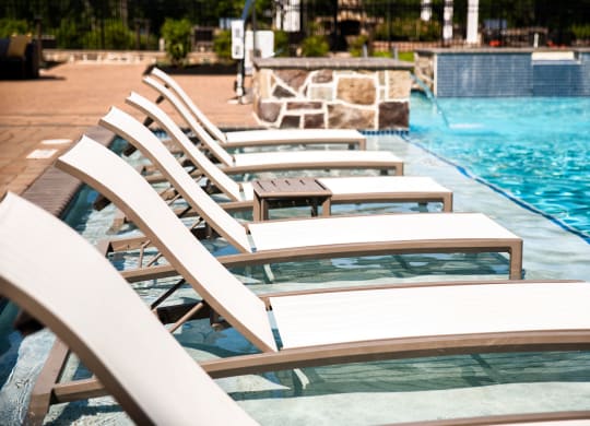 a row of beach chairs sitting next to a pool  at Heights at Glen Mills, Glen Mills, PA