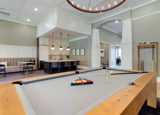 a pool table in the center of a living room with a kitchen at Madison on the Meadow, Texas