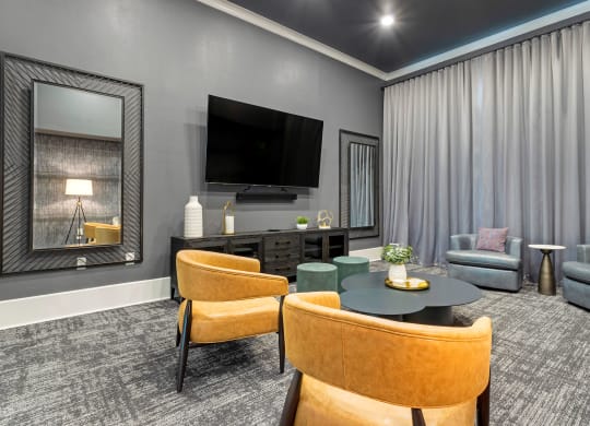 a living room with a tv and a table and chairs at Madison on the Meadow, Stafford, TX, 77477