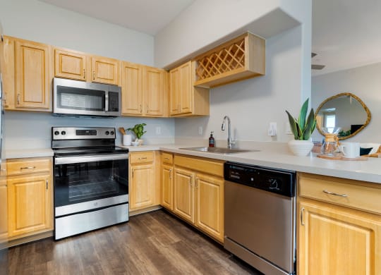 a kitchen with wooden cabinets and stainless steel appliances at Madison on the Meadow, Stafford