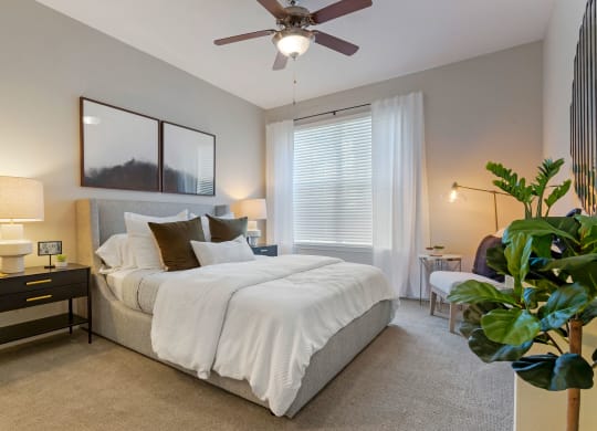 a bedroom with a large bed and a ceiling fan at Madison on the Meadow, Stafford, TX