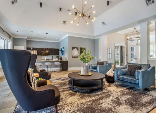 a living room with blue furniture and a chandelier at Reserve by the Lake, Houston