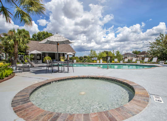 In Ground Hot tub with View of the Pool with chairs and an umbrella at Reserve by the Lake, Texas