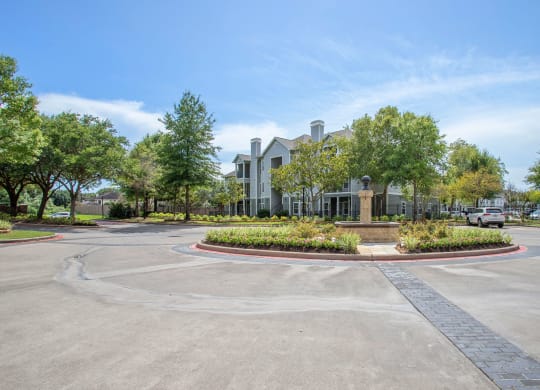 Entryway Roundabout with Apartment Building in the background at Reserve by the Lake, Houston