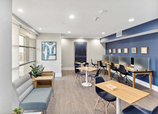 A room with a blue wall and a white ceiling with a painting on the wall at The Kitt at Warner Center Apartments, Woodland Hills, California