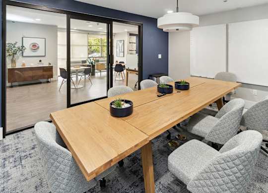 A conference room with a long table and grey chairs at The Kitt at Warner Center Apartments, Woodland Hills 91303