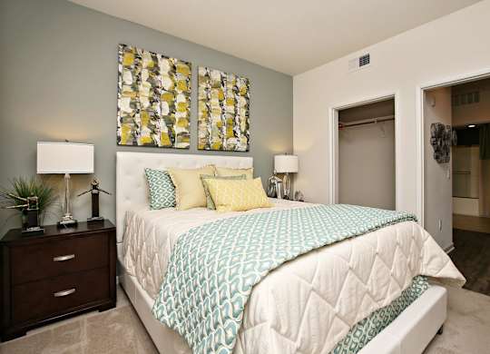 A bedroom with a bed, nightstand, and lamp at The Kitt at Warner Center Apartments, California, 91303