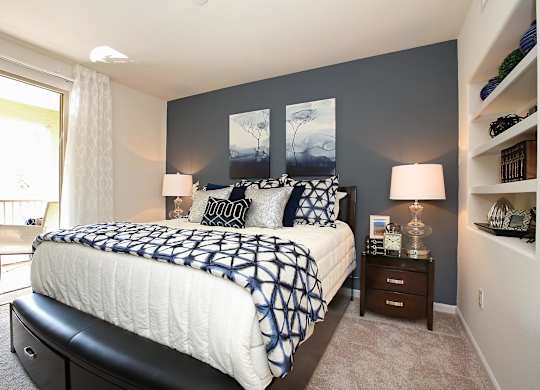 A bedroom with a large bed and a window with curtains at The Kitt at Warner Center Apartments, Woodland Hills 91303