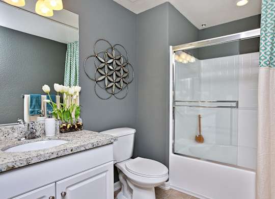 A bathroom with a toilet, sink, and shower at The Kitt at Warner Center Apartments, California, 91303