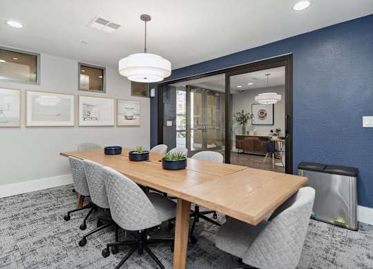 A conference room with a long table and chairs at The Kitt at Warner Center Apartments, California