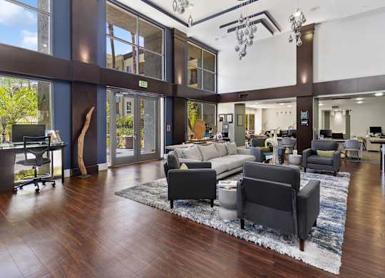 A modern living room with a large rug and a long couch at The Kitt at Warner Center Apartments, Woodland Hills, CA, 91303