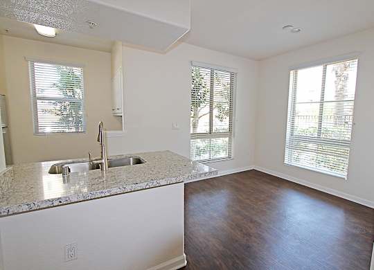 A kitchen with granite countertops and a sink at The Kitt at Warner Center Apartments, Woodland Hills, CA, 91303