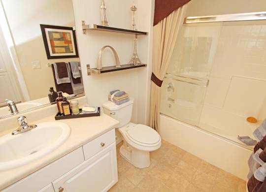 A bathroom with a toilet, sink, and shower at The Kitt at Warner Center Apartments, Woodland Hills, CA, 91303