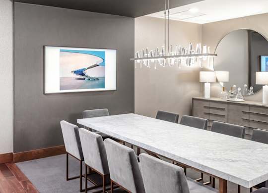 Modern dining room with a long table and grey chairs at 365 Nicollet, Minneapolis, Manchester
