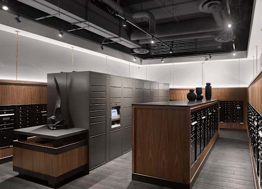 A modern office lobby with a reception desk and two people standing behind it.