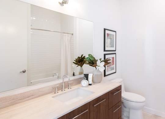 A bathroom with a white sink and a white toilet.