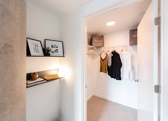 A hallway with a coat rack and a few items on a shelf.