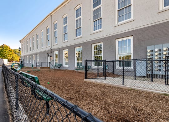 a building with a fenced in yard and a chain link fence at Highland Mill Lofts, Charlotte, NC
