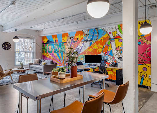 a living room with a table and chairs and a mural on the wall at Highland Mill Lofts, Charlotte, North Carolina