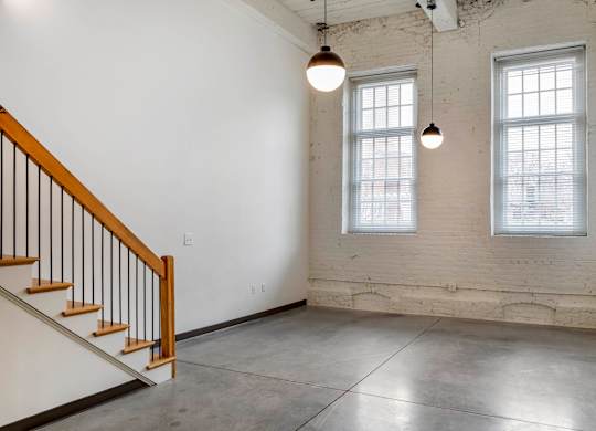 an empty room with two windows and a staircase at Highland Mill Lofts, Charlotte, North Carolina