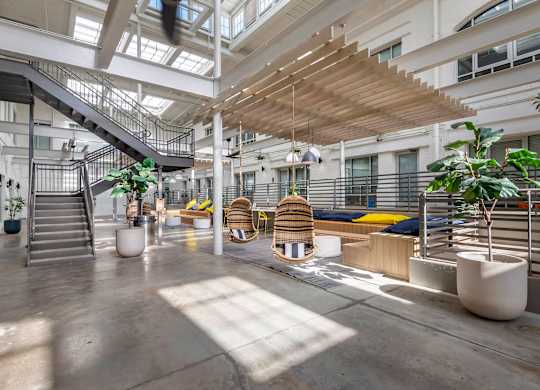 the lobby of an office building with stairs and plants at Highland Mill Lofts, Charlotte, NC