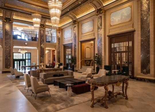 a large lobby with couches and chairs and a table  at The Belden Stratford, Illinois