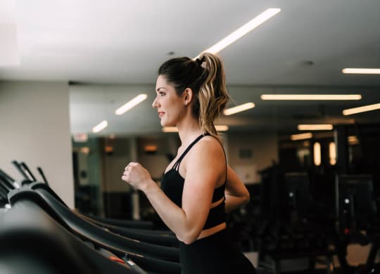 a woman running on a treadmill at the gym at The Grand Central, Illinois, 60607