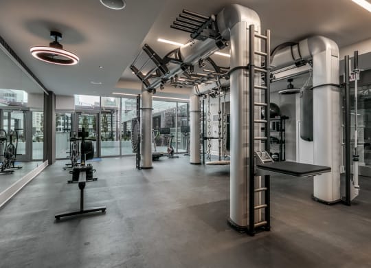 a workout room with equipment and pipes in a building at The Grand Central, Chicago, IL 60607