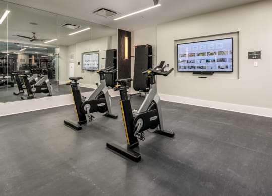 a gym with treadmills and other exercise equipment in a room with a tv at The Grand Central, Illinois