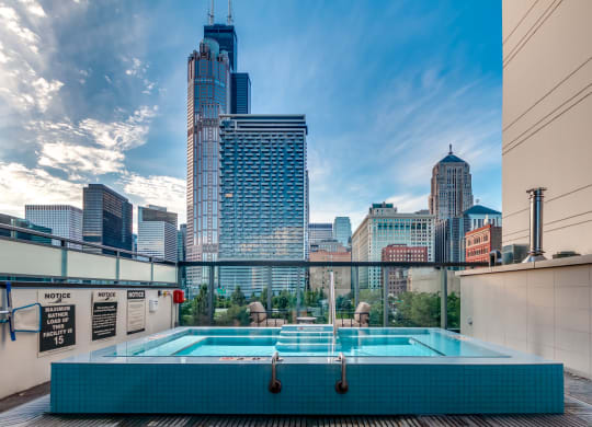 a pool on the roof of a building with a city in the background at The Grand Central, Illinois
