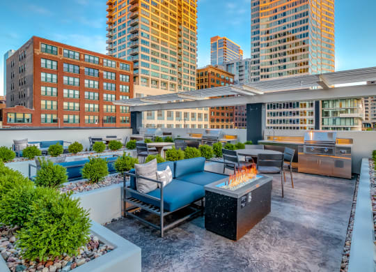 a rooftop patio with a fire pit and a city skyline at The Grand Central, Chicago, IL