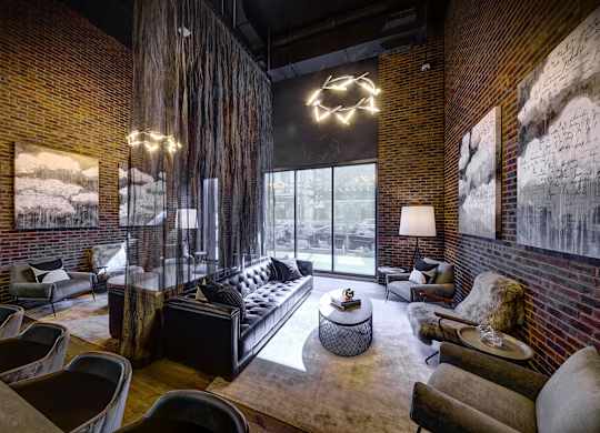 A living room with a black couch and a large window. at The Mason Apartments, Chicago