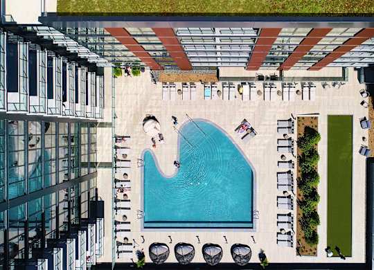 A swimming pool surrounded by lounge chairs and umbrellas. at The Mason Apartments, Illinois, 60607