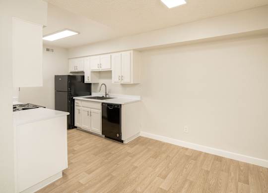 A kitchen with black appliances and white cabinets.