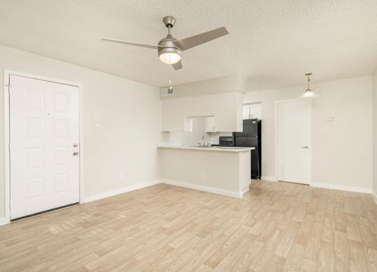 A room with a ceiling fan and wooden flooring.