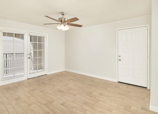 A room with a ceiling fan and a door.