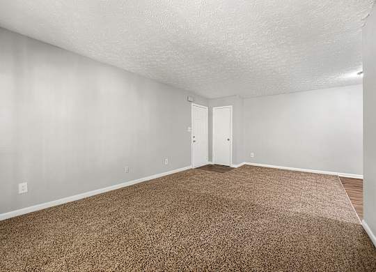 A room with brown carpet and white walls.