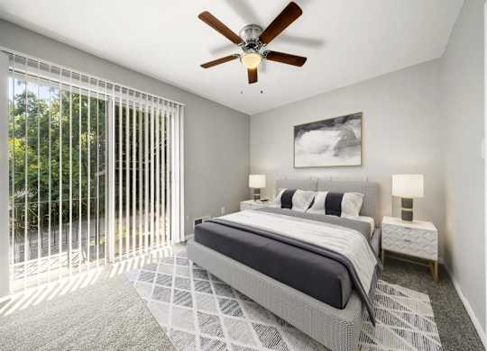 Master bedroom with ceiling fan and light with bed at Georgian Oaks Apartments l & ll* Apartments, Smyrna , Georgia
